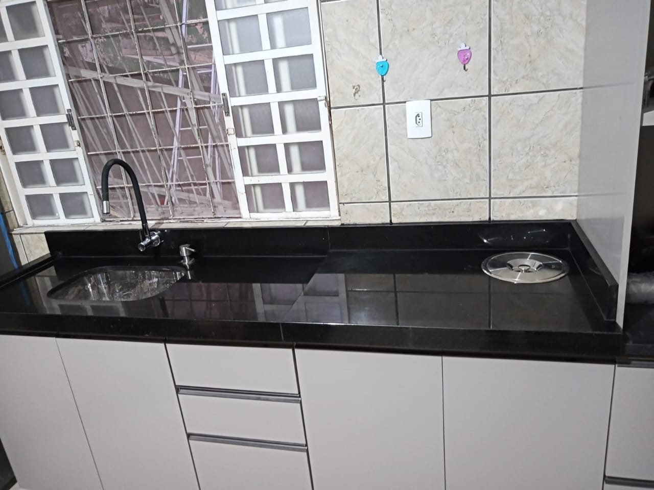 Cozinha com bancada em granito preto polido, cuba embutida e lixeira embutida na pedra