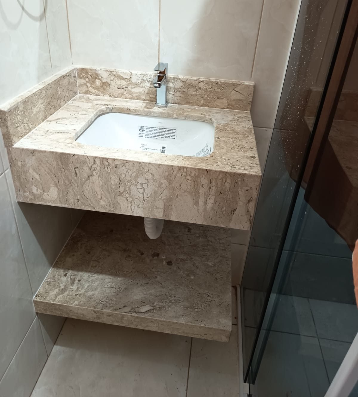 Lavatório compacto em mármore travertino com cuba embutida, frontão e prateleira inferior em pedra